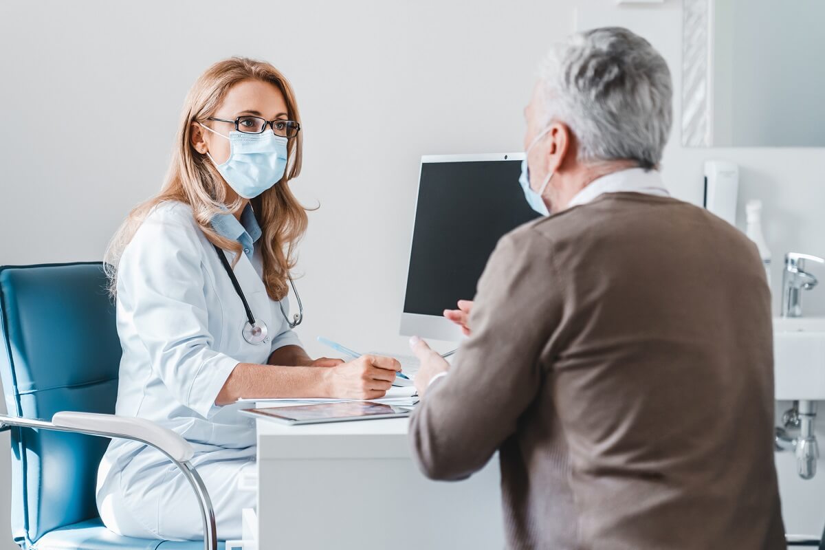 Adult Gerontology Nurse Practitioner in Mask Consulting with Adult Patient