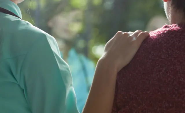 Psychiatric-Mental Health Nurse Practitioner PMHNP placing hand on patient's shoulder giving comfort