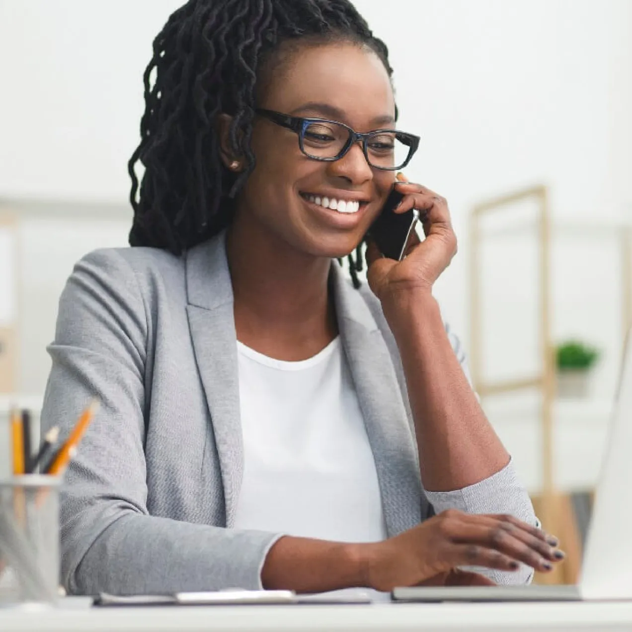 Medical billing specialist in office at desk speaking with team member on phone