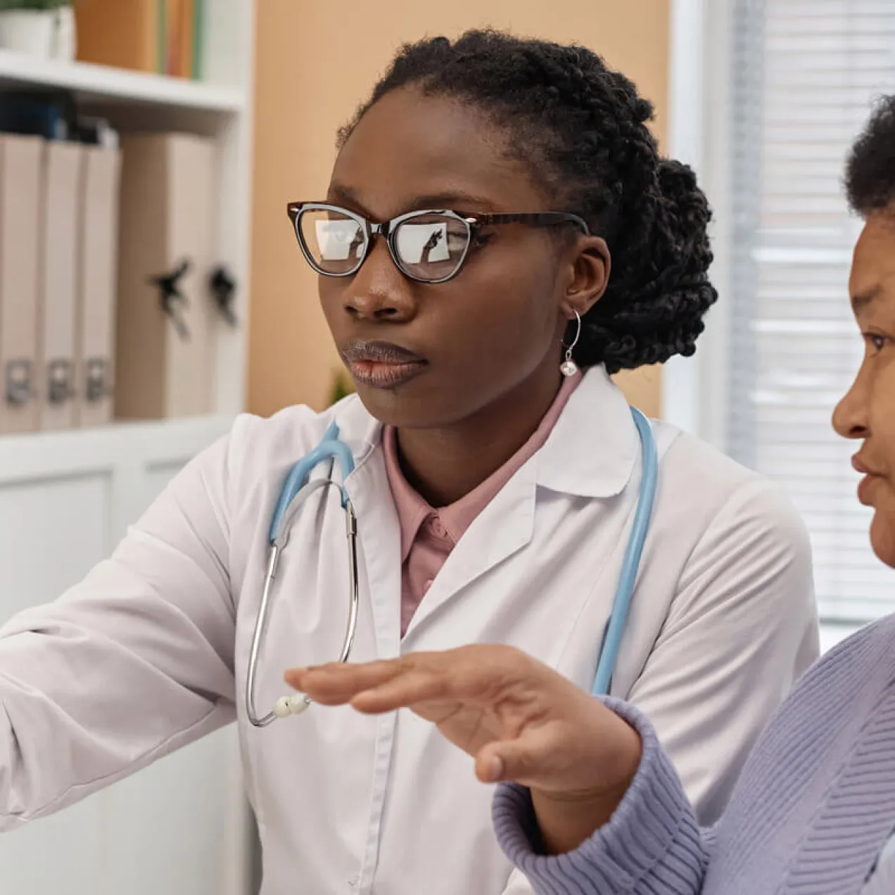 Primary care nurse practitioner with DNP reviewing treatment with patient