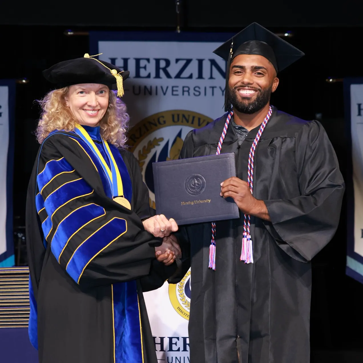 Herzing graduate receiving his diploma from University President.