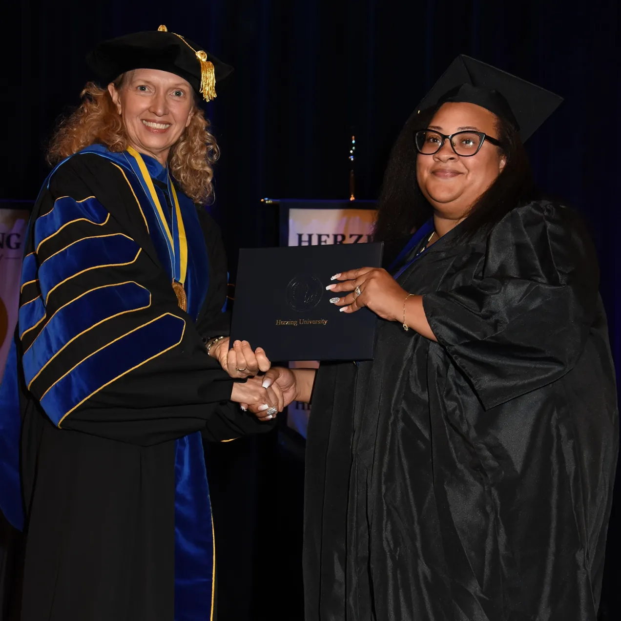 Herzing graduate receives diploma from Renee Herzing