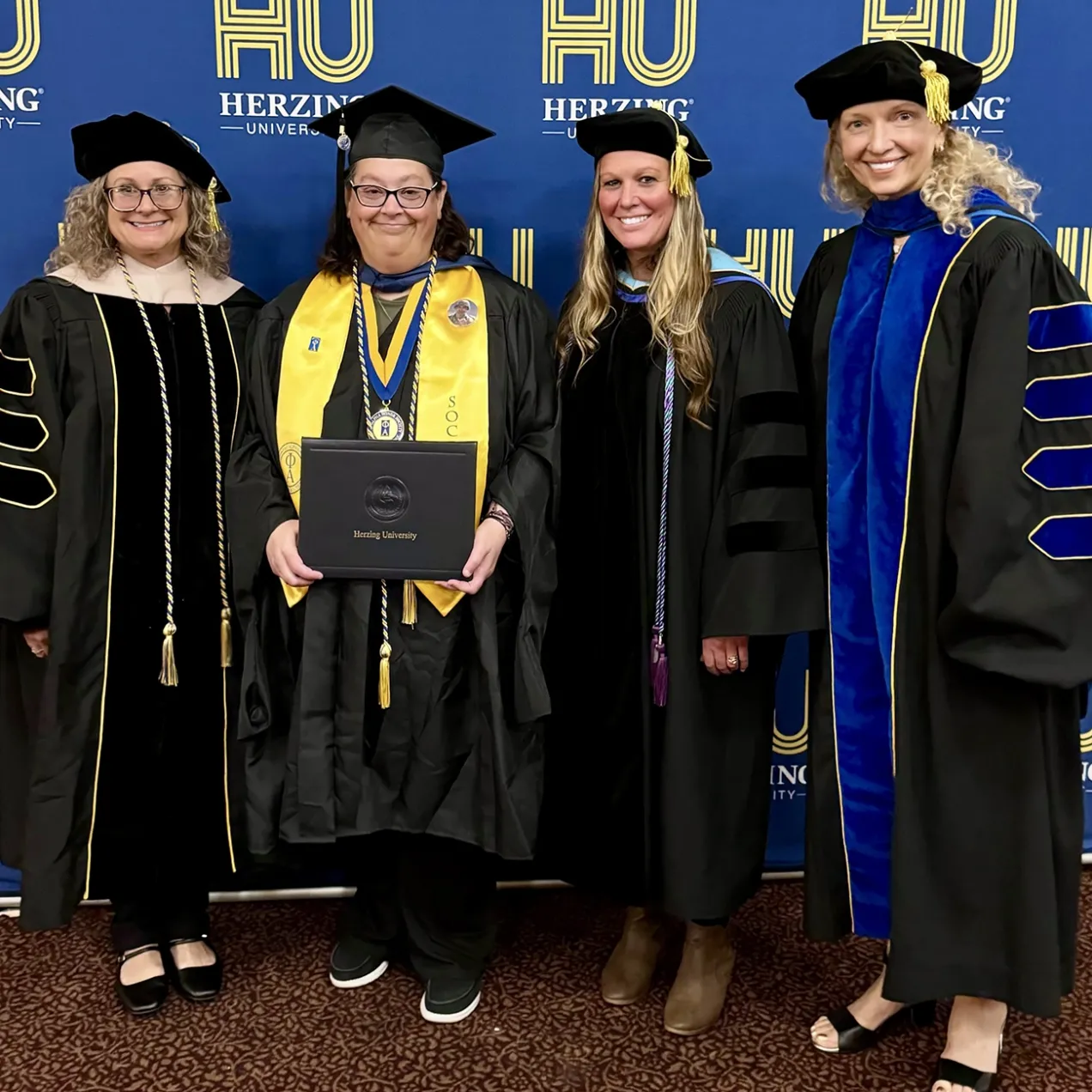 Herzing MSW graduate displays diploma with school president