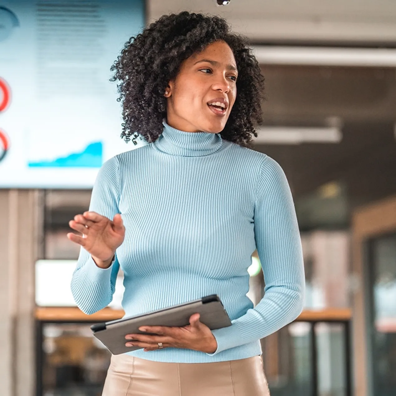 A confident business professional presents data during a meeting, demonstrating leadership and analytical skills gained through an MBA.