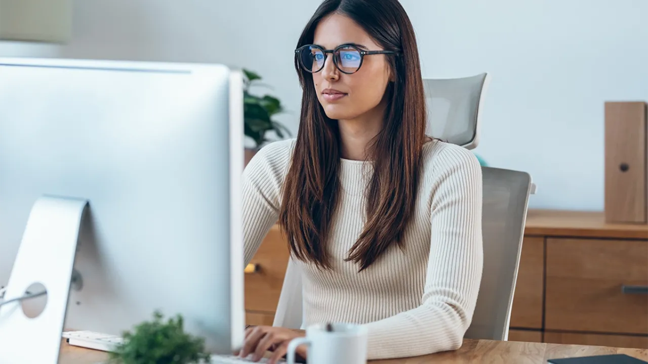 Medical billing and coding specialist seated in front of computer at desk in home office
