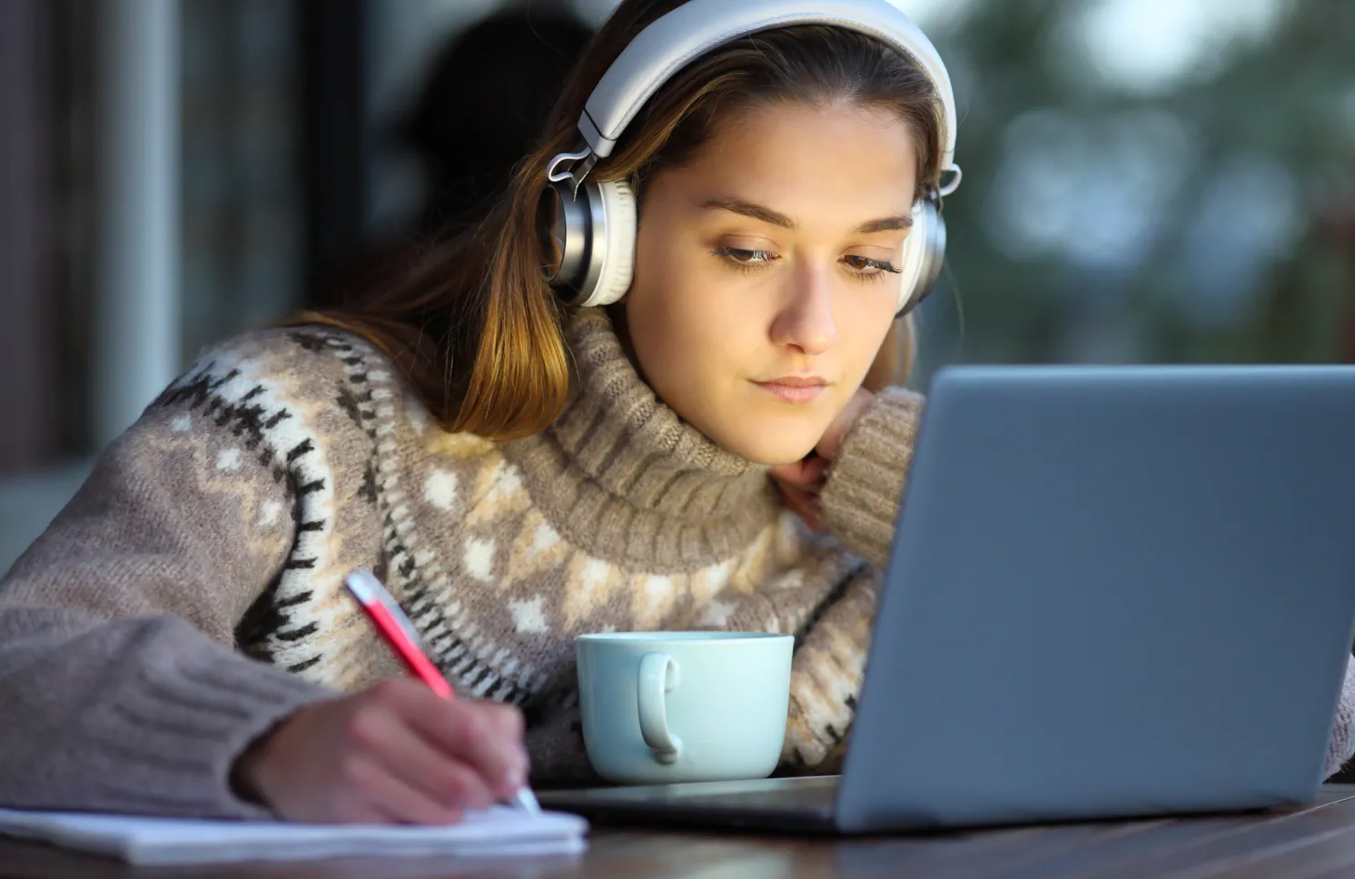 Student e-learning in a coffee shop in winter