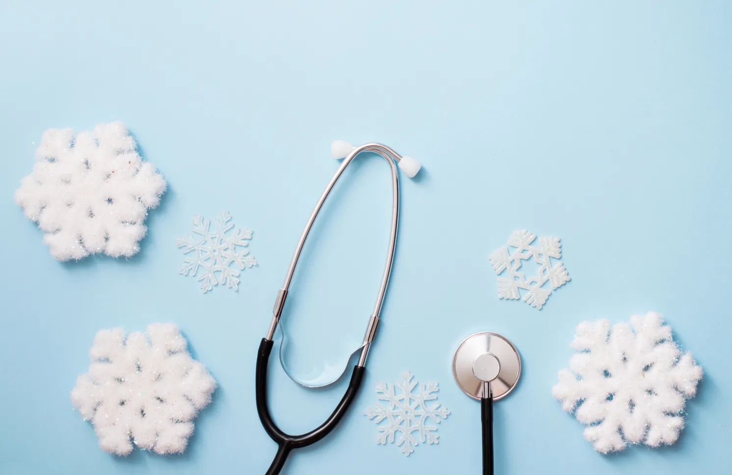 blue background with stethoscope and snowflakes, medical winter holiday. copy space