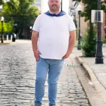 Christopher Green standing in the middle of the street in a grad cap