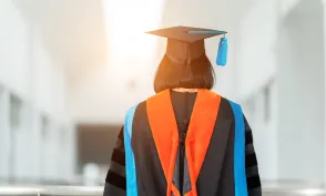 PhD student with their back facing viewer wearing an orange nursing hood