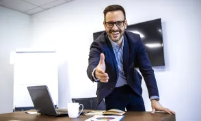 Portrait of businessman in elegant suit showing welcoming hand to the new employees.