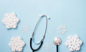 blue background with stethoscope and snowflakes, medical winter holiday. copy space