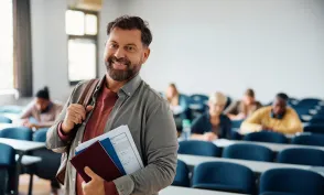 Happy mature man attending adult education training course and looking at camera.