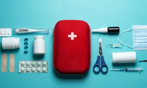 Home first aid kit on a blue background. The elements of the first aid kit