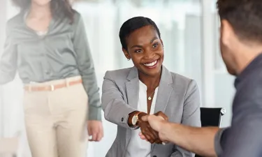 Atlanta business woman with online MBA shaking hands after securing deal