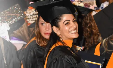 Herzing RN to BSN graduate smiling at graduation ceremony