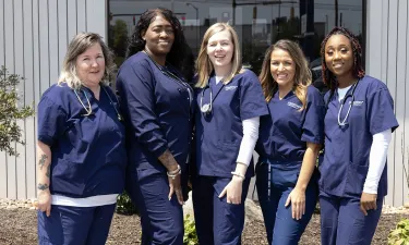 Herzing practical nursing students smiling outside campus