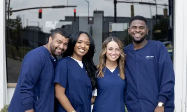 Group of Montana medical assisting students smiling outside in navy scrubs, showcasing camaraderie and professionalism