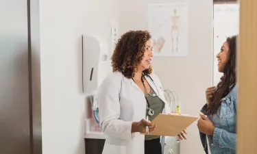 Women's health nurse practitioner smiling in clinic