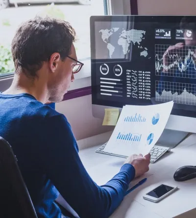 Data Analyst Reviewing Analytics Report at Computer