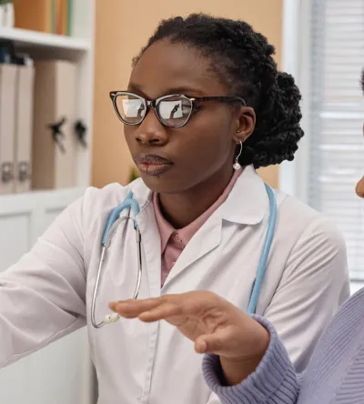 Primary care nurse practitioner with DNP reviewing treatment with patient