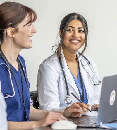 Nurse Practitioner Who Went From RN to MSN Online Smiling with Patient