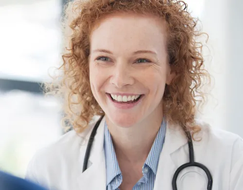 Women's health nurse practitioner WHNP smiling with patient during consultation