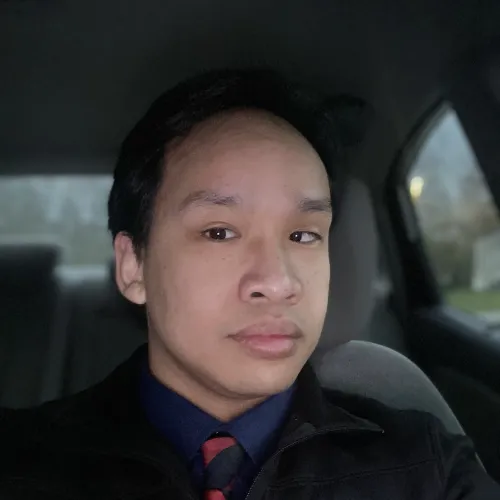 Man in a suit takes a selfie in a car