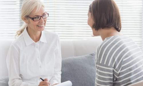 Psychiatric Mental Health Nurse Practitioner PMHNP Smiling with Adult Patient