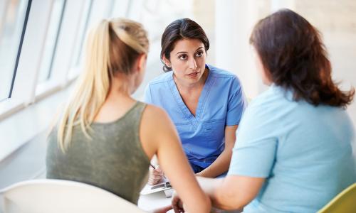 Registered nurse with bachelor's degree speaking with patients in hospital