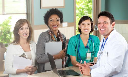 Public Health Nurse with Healthcare Team Smiling in Clinic 