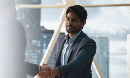 MBA business analytics graduate shaking hands with coworker