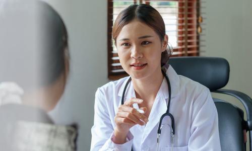 Mental health professional in a white coat talking to a patient