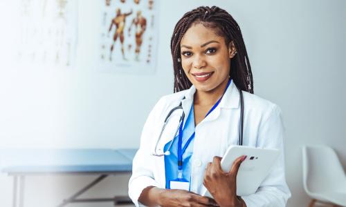 Women's health nurse practitioner with DNP smiling in clinic