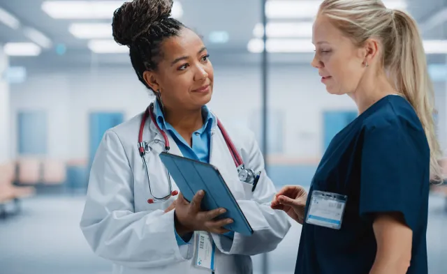 Nurse Practitioner Showing Patient Chart to Registered Nurse