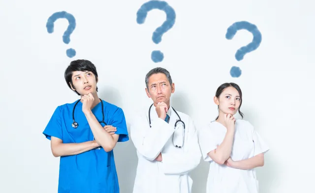 Three medical professionals deep in thought with question marks over their heads