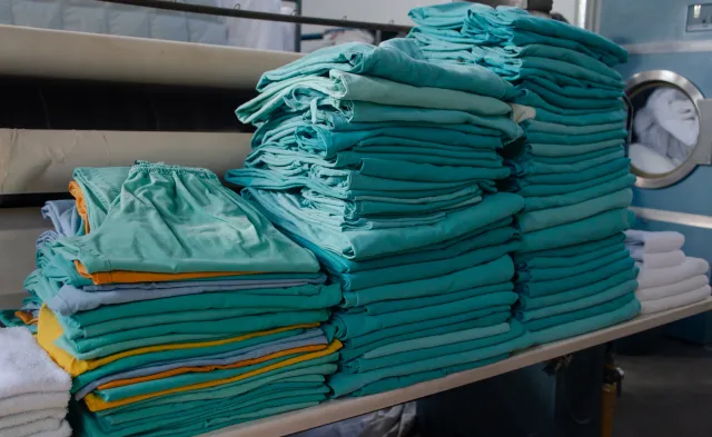 Stack of modern day green scrubs neatly folded in a pile