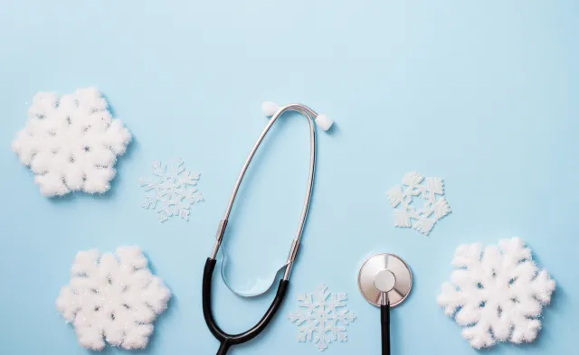 blue background with stethoscope and snowflakes, medical winter holiday. copy space