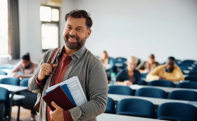 Happy mature man attending adult education training course and looking at camera.