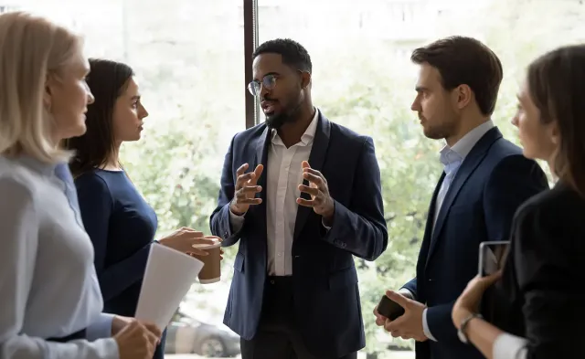 Business manager discussing strategy with team members in well lit office