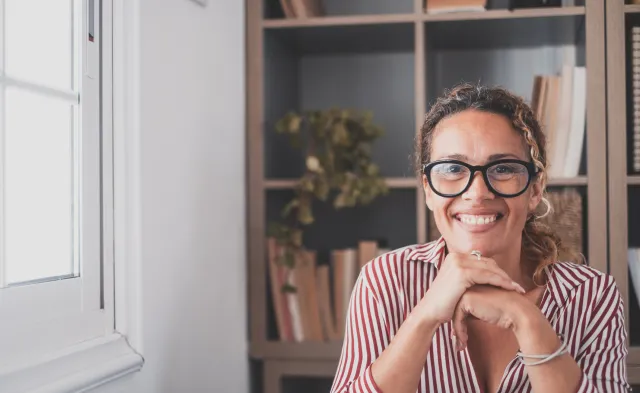 Portrait of one young and happy cheerful woman smiling looking at the camera having fun. Headshot of female person working at home in the office.