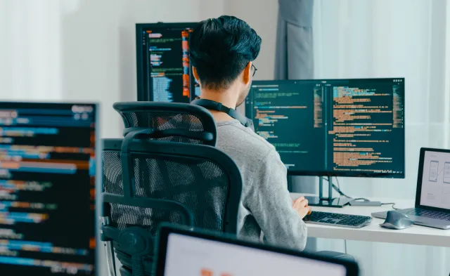 Young adult Asia male freelance eyeglasses typing write prompt AI bot IT app smart program nomad, video game, terminal with coding, user interface, designer, big data center on desktop computer.