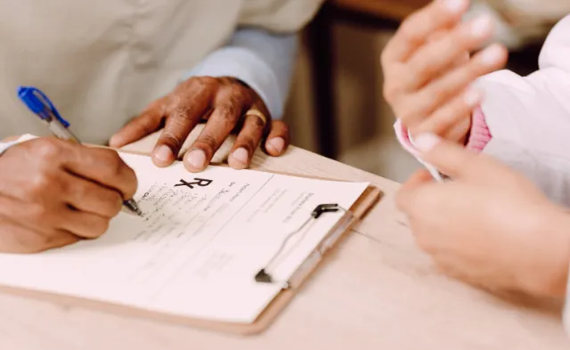 Nurse Writing Prescription with Nurse Educator's Guidance