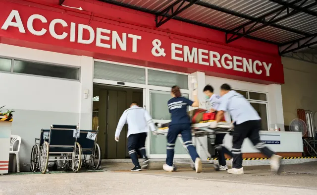Team of emergency medical service workers wheeling patient on stretcher into the hospital during an emergency situation