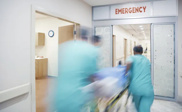 Nurses wheeling patient in emergency room
