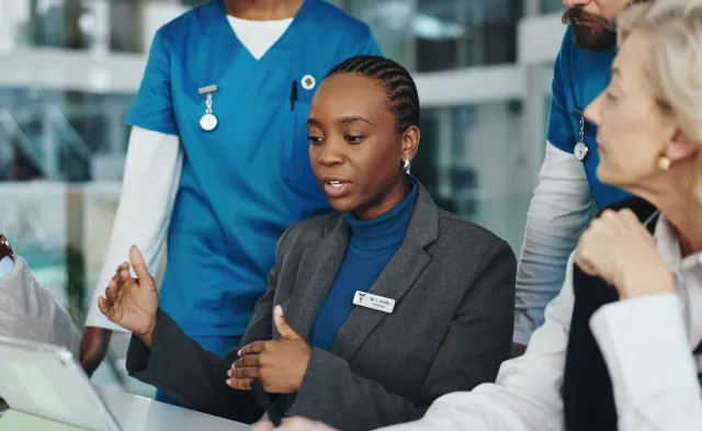 Doctors, nurses or meeting with tablet in hospital for surgery schedule, task delegation or planning. Medical staff, people and feedback with tech for clinic management, healthcare cost and teamwork