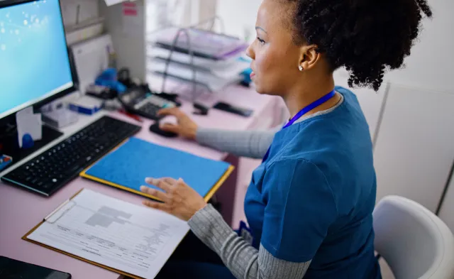 Black woman using computer to work as nurse in the private clinic.Black woman using computer to work as nurse in the private clinic.