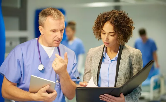 Nursing administrator reviewing patient diagnosis and treatment with registered nurse