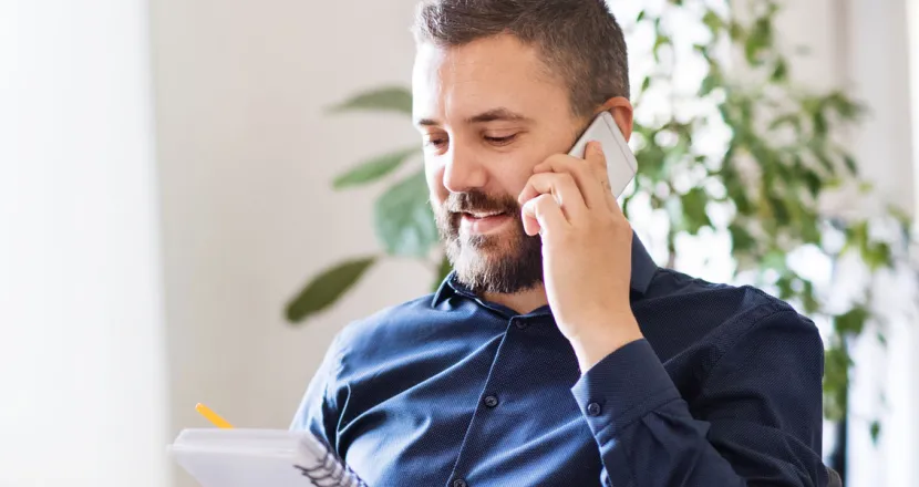 IT Manager Discussing Team Strategy On Phone In Office