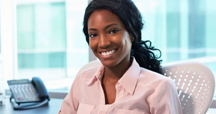 Medical Office Administrator Smiling at Desk