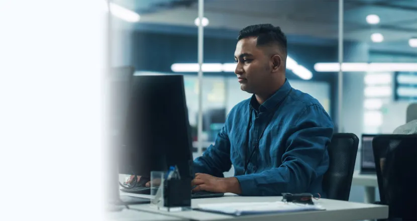 Software Developer Seated at Computer Desk In Office